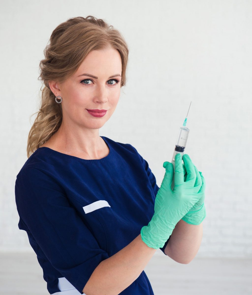 young-woman-cosmetologist-in-blue-uniform-holding-syringe-beauty-face-injection.jpg
